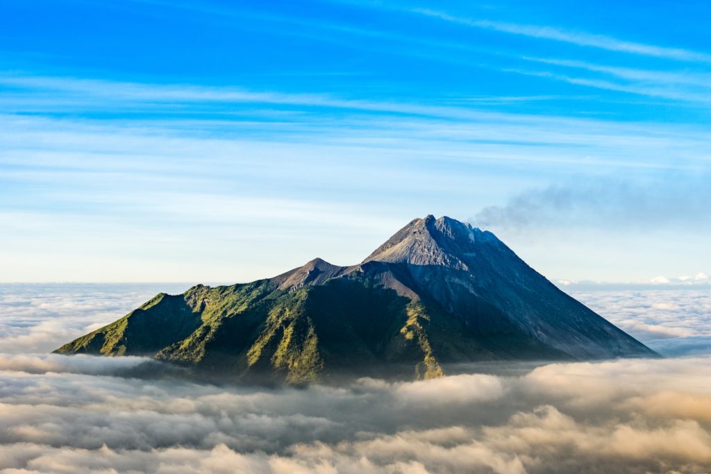 Gebirgskette, die tagsüber mit Wolken unter blauem Himmel bedeckt ist